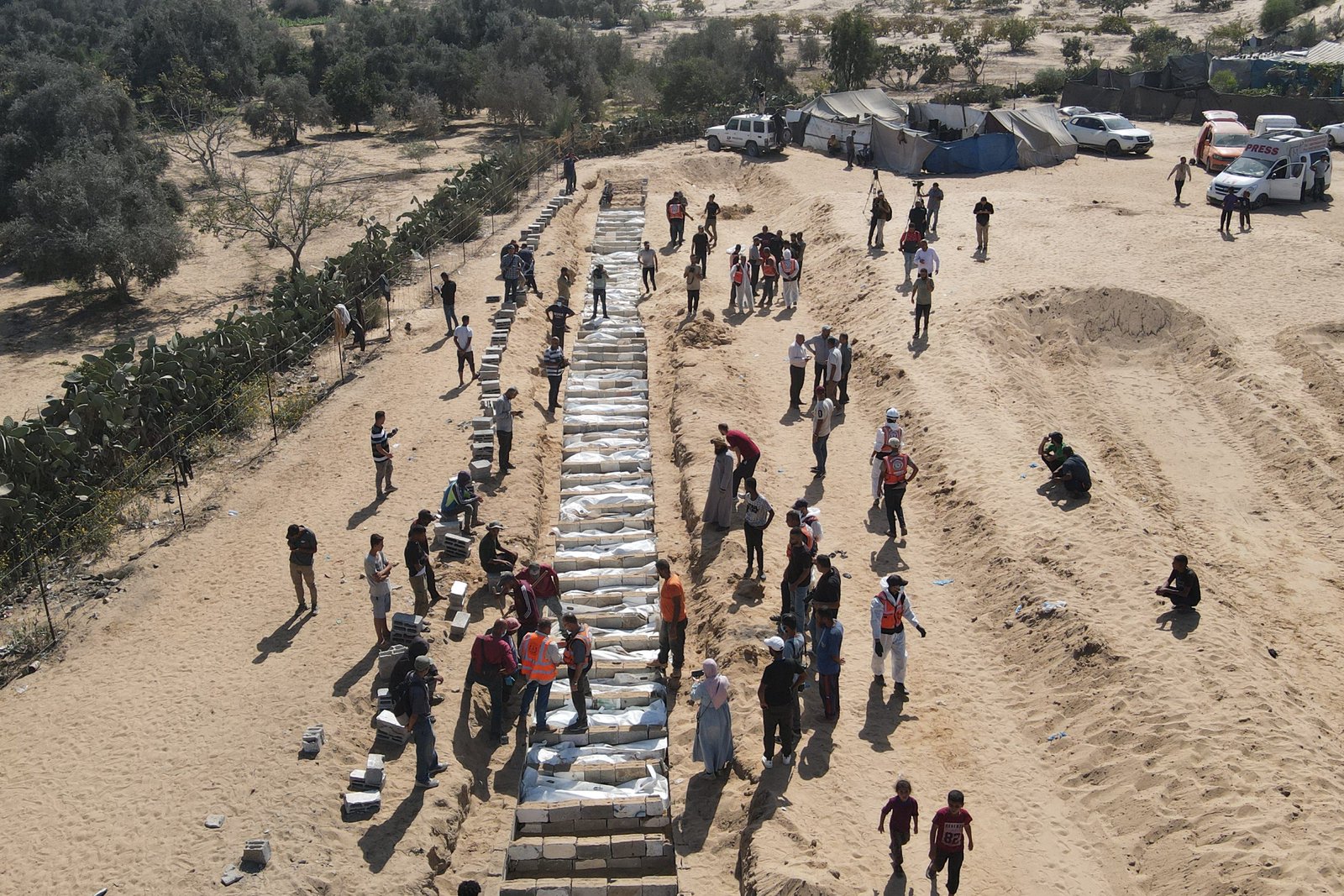 Dozens of unidentified bodies returned by Israel buried in a mass grave in Gaza; Trump seeks $230 million compensation for past federal investigations